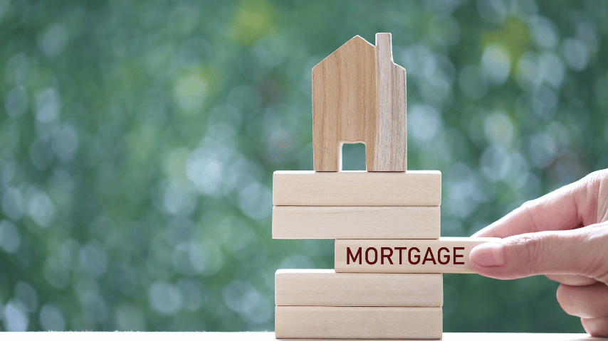 Model House On Wooden Block with the word Mortgage. Home Mortgage and Real Estate Investment Model